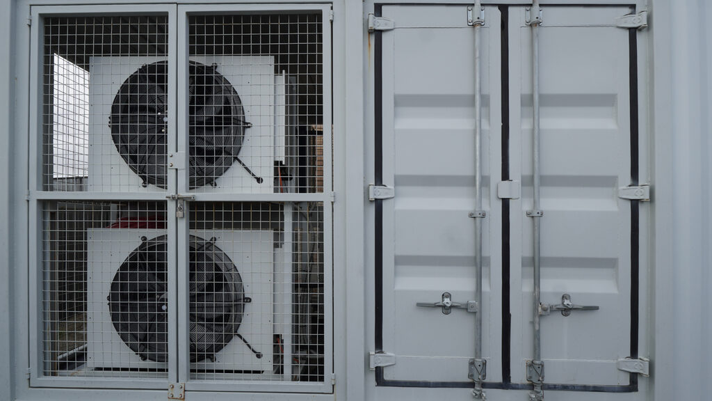 Containerised data module exterior with caged HVAC cooling fans and secured access doors