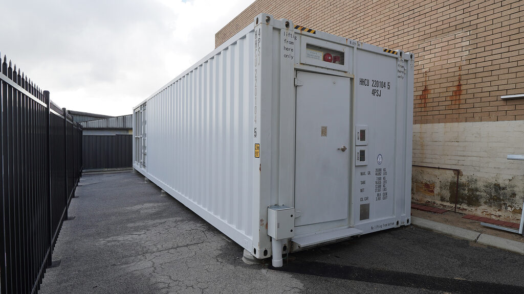 Modular shipping-container data centre on-site, secured behind steel perimeter fencing