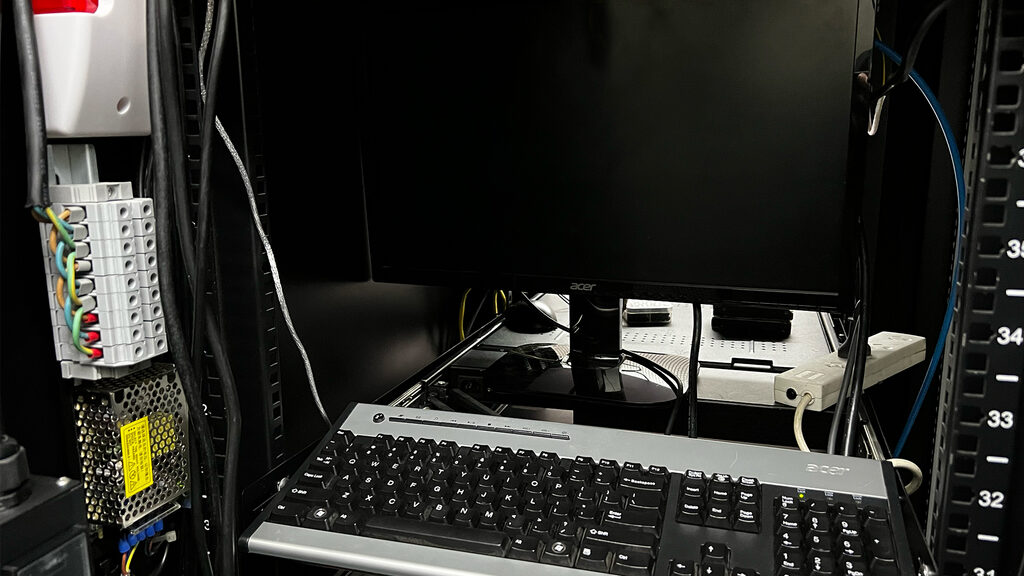 Rack-mounted KVM workstation with monitor and keyboard inside a colocation server cabinet